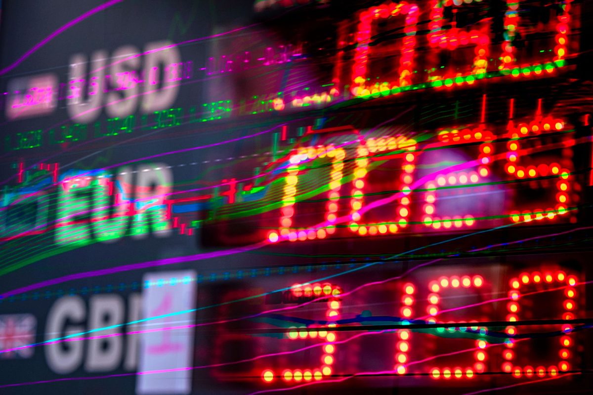 원/달러 환율 1500원을 가리키는 환율 전광판과 미국 주식 차트